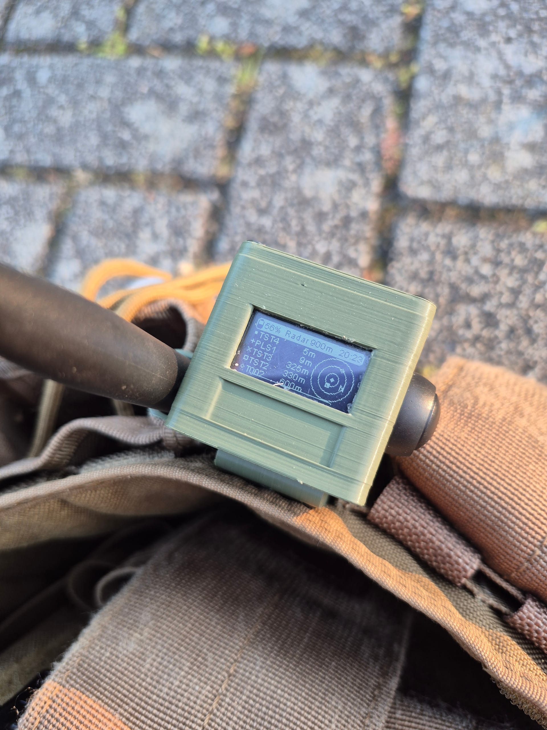 Close-up of olive RBaken radar screen on plate carrier over cobblestone