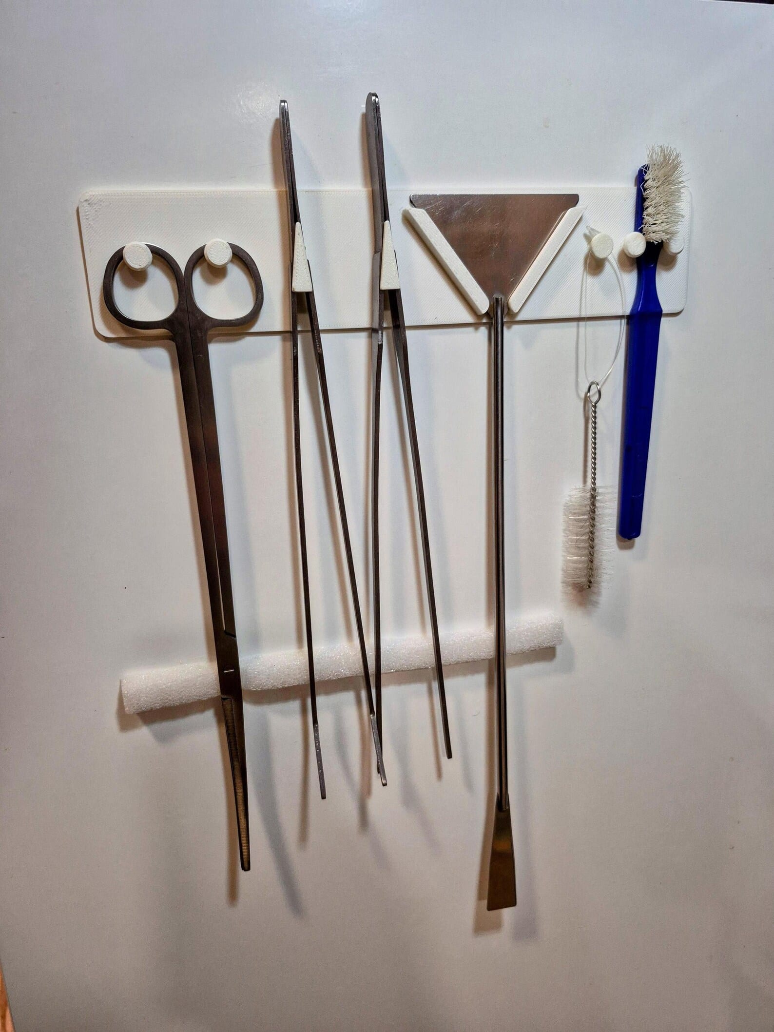 Aquascaping tools holder mounted on wall with full set of tools